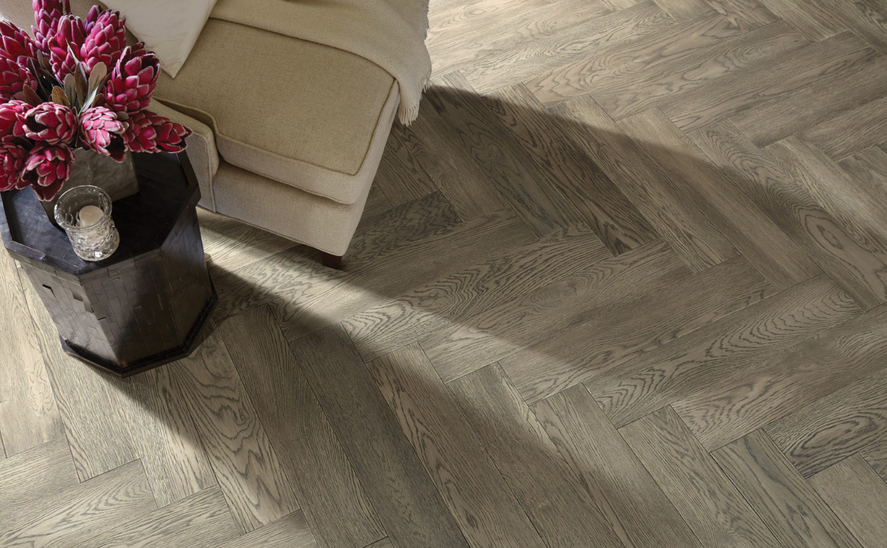 Herringbone hardwood floor with dark red/pink flowers 